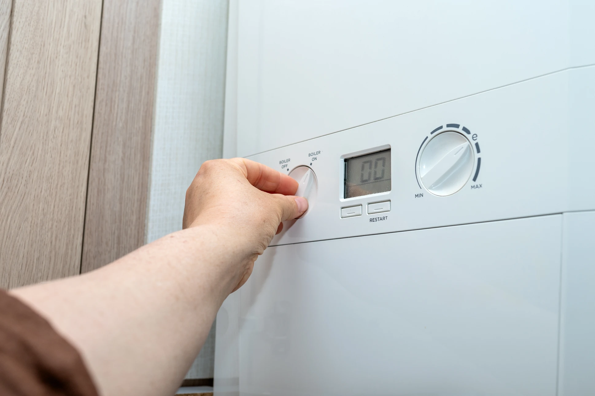 Technicien en plomberie intervenant sur installation de chauffage domestique dans local technique résidentiel